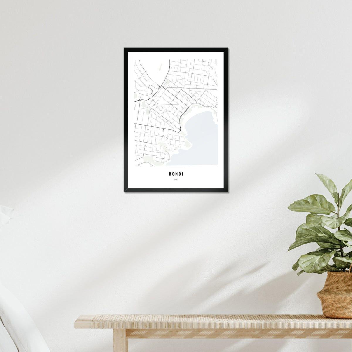 Bondi Map poster in a black frame above a bed