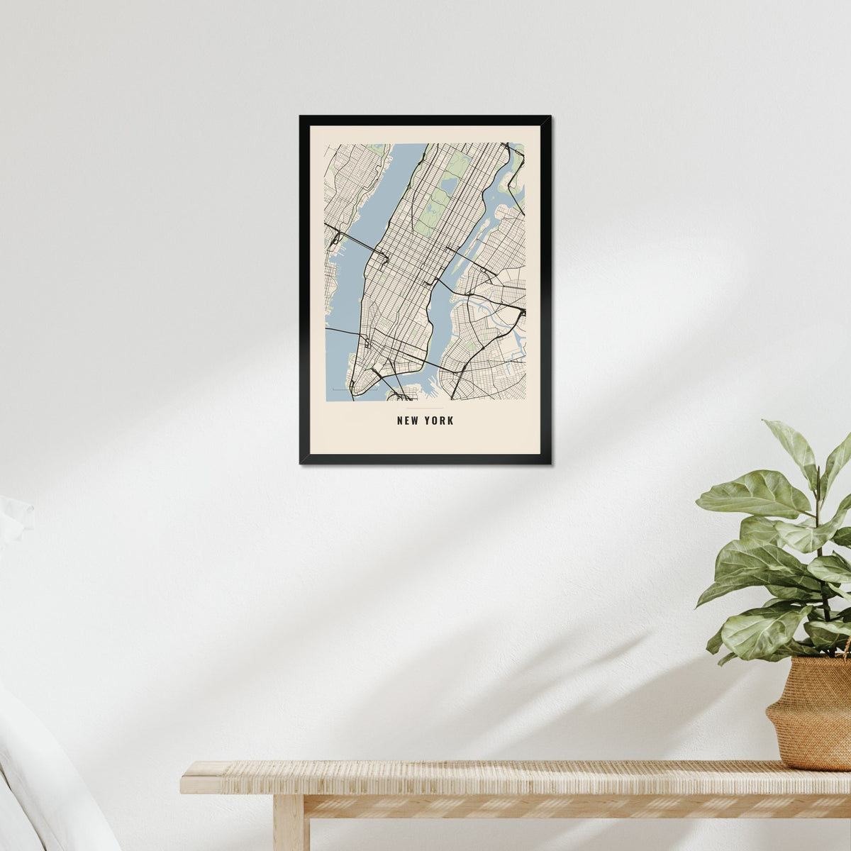 Example city map poster in a black frame above a bed