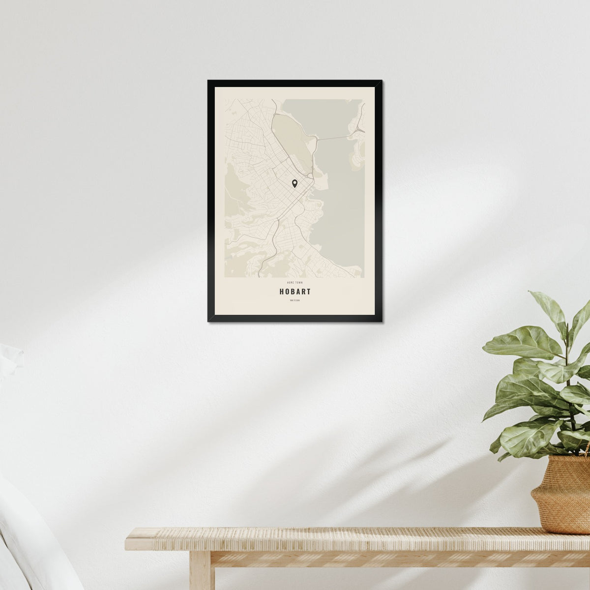 Home Town Map poster in a black frame above a bed