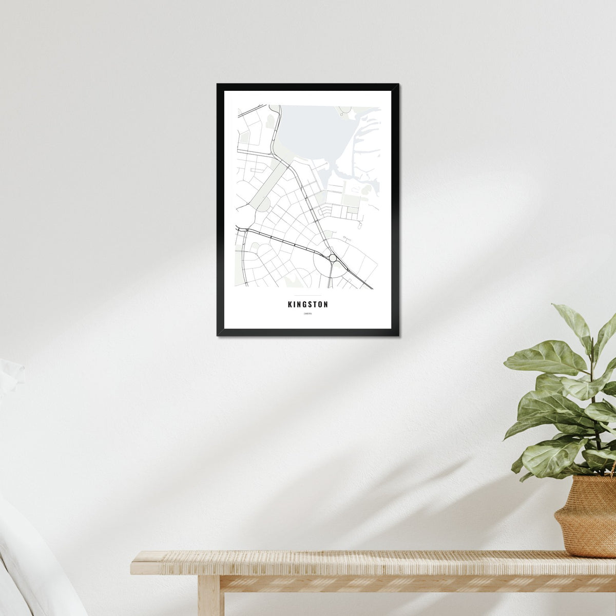 Kingston Map poster in a black frame above a bed