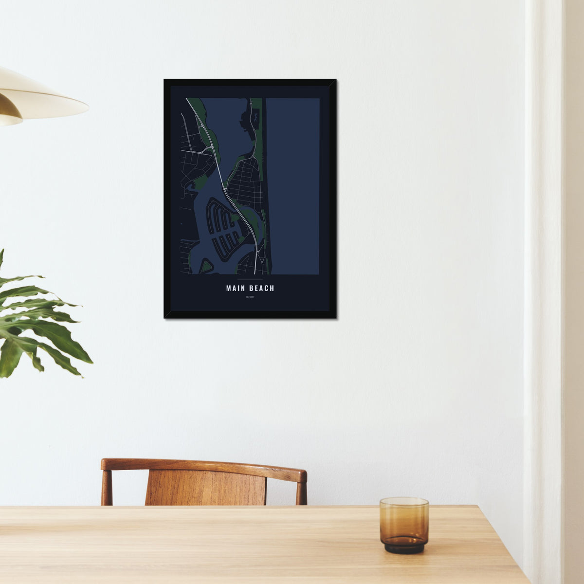 Main Beach Map poster in a black frame on a dining room wall