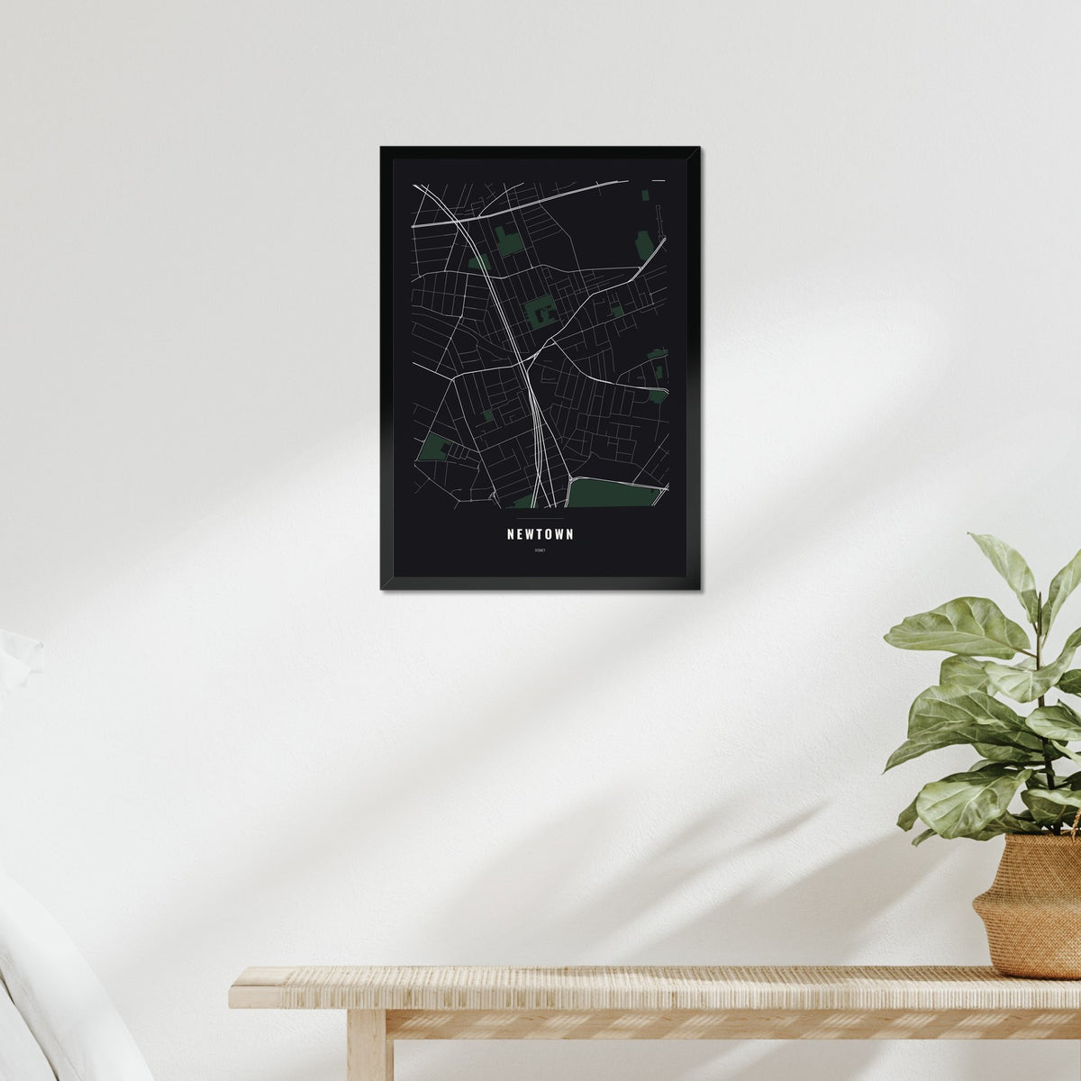 Newtown Map poster in a black frame above a bed