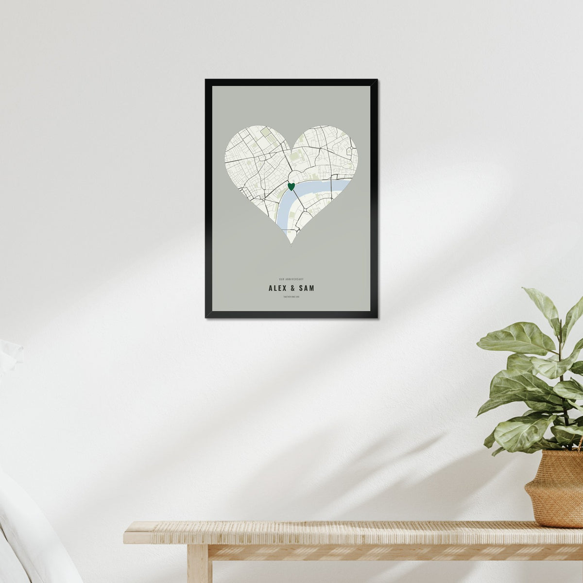 Our Anniversary Map poster in a black frame above a bed