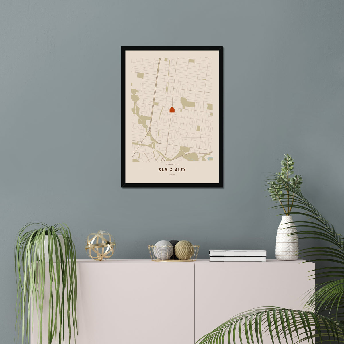 Our First Home Map poster in a black frame in a living room