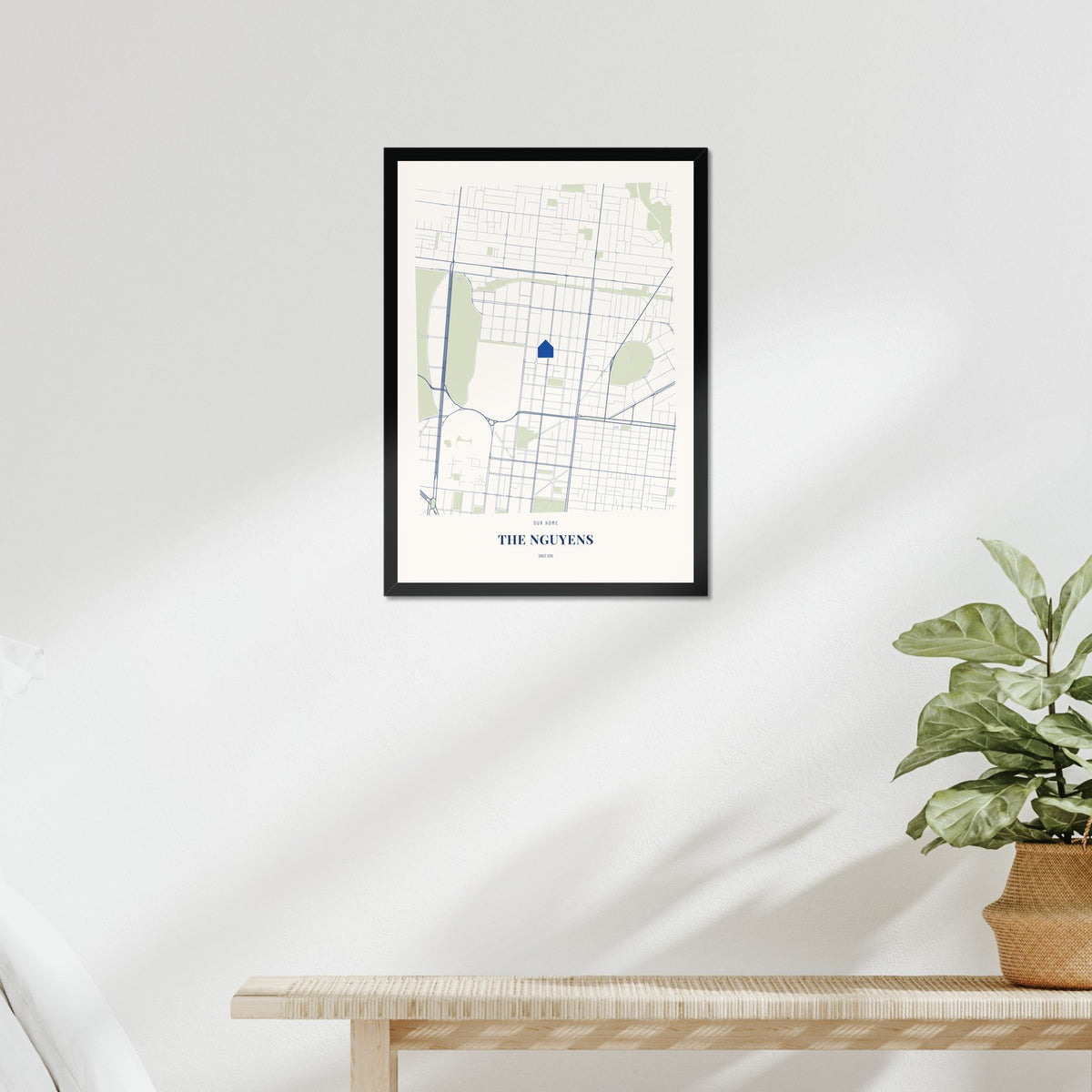 Our Home Map poster in a black frame above a bed