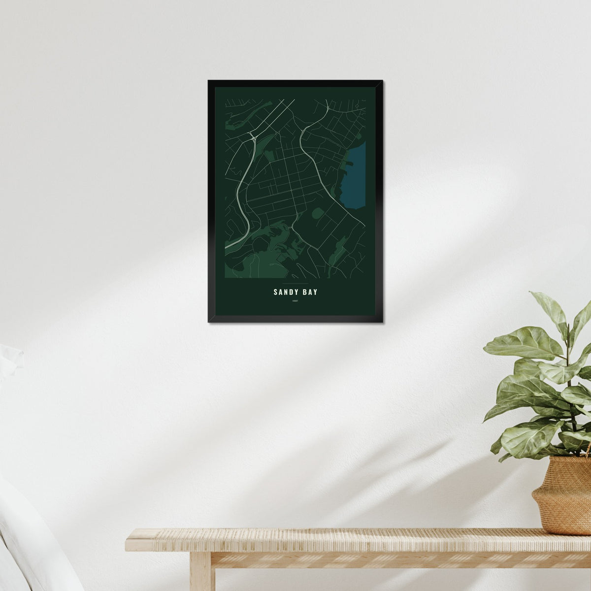 Sandy Bay Map poster in a black frame above a bed