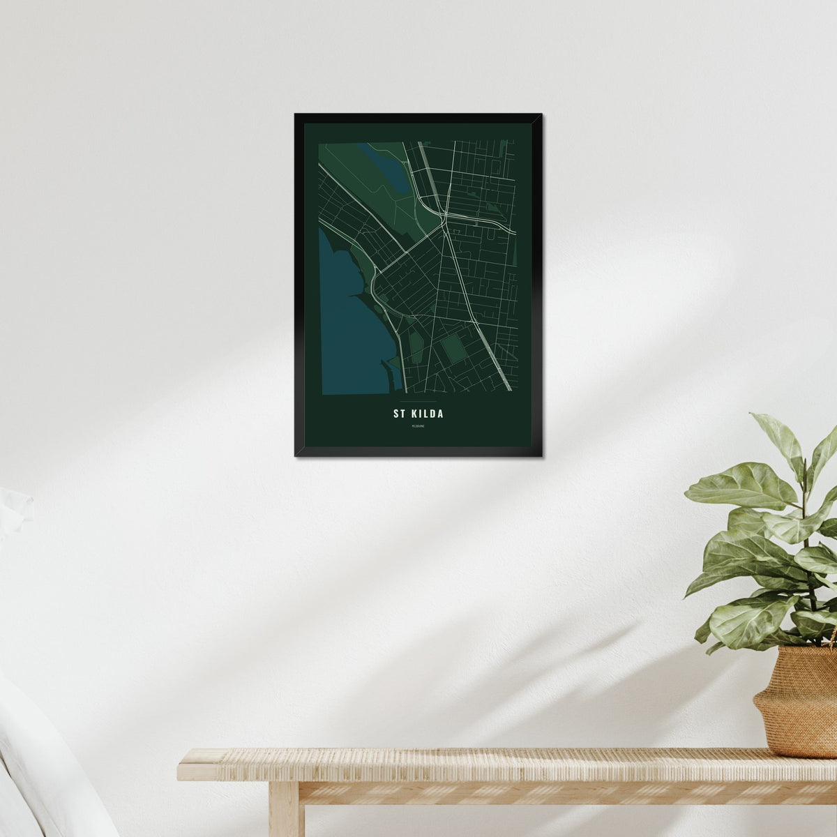 St Kilda Map poster in a black frame above a bed